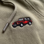 Close-up of the red Jeep Wrangler embroidery on khaki fleece, near the hood drawstring