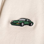 Close-up of the green Porsche 911 embroidery on the sweatshirt's ecru fleece