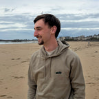 Khaki Overcut hooded sweatshirt with Porsche 911 embroidery, worn on a beach