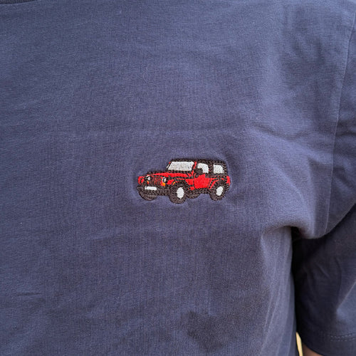 Gros plan de la broderie Jeep Wrangler rouge sur coton bleu