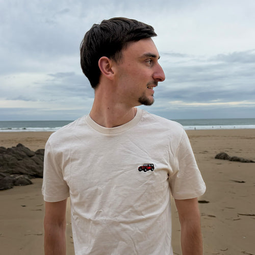 T-shirt Overcut écru à broderie Jeep Wrangler, porté sur une plage