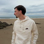 Ecru Overcut hooded sweatshirt with Jeep Wrangler embroidery, worn on a beach